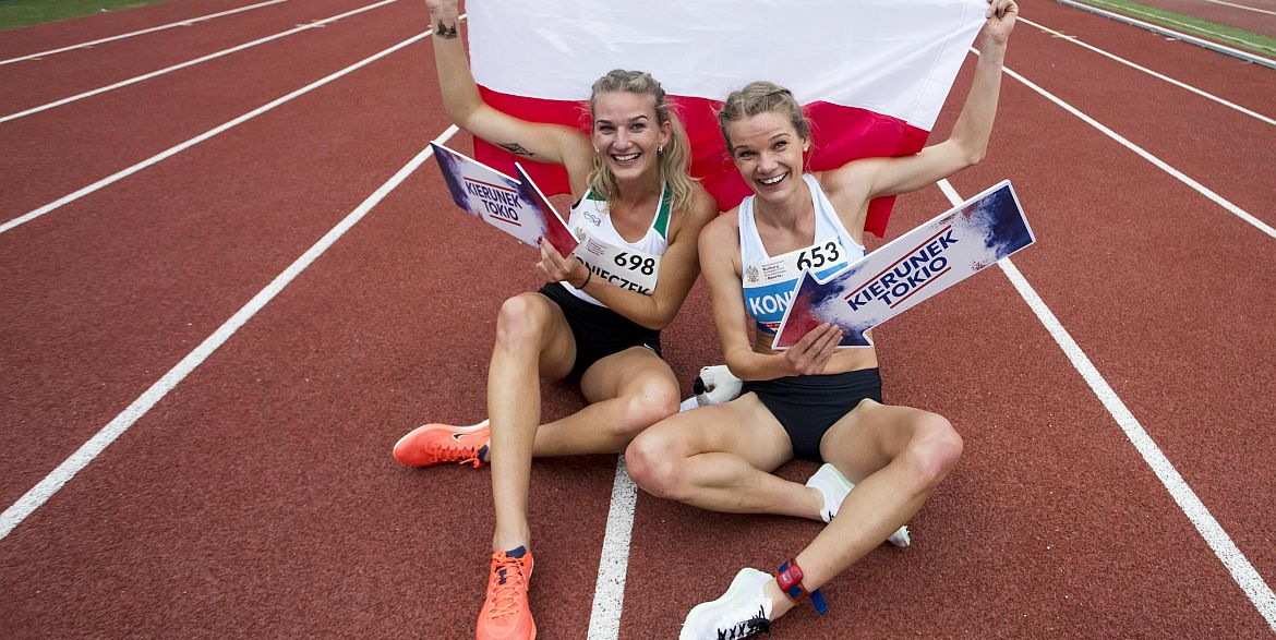 Siostry Konieczek trzymają tabliczki z napisem kierunek Tokio oraz flagę Polski